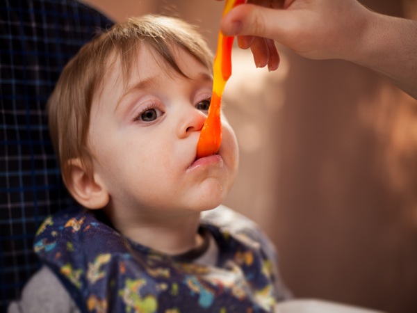 Pretty baby boy being fed by mom