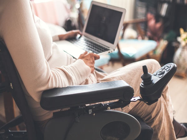 Woman in wheelchair using laptop
